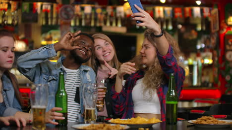Grupo-De-Amigos-Diversos-Tomándose-Selfie-En-Un-Teléfono-Móvil-En-El-Bar.